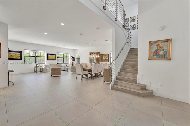 stairway featuring recessed lighting, an inviting chandelier, baseboards, and tile patterned floors