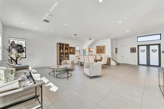 living room featuring french doors, visible vents, stairway, and light tile patterned floors