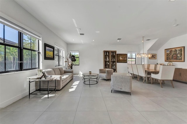 living area featuring plenty of natural light, visible vents, a notable chandelier, and light tile patterned flooring