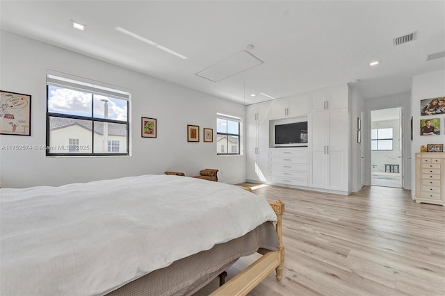 bedroom with recessed lighting, visible vents, attic access, light wood-style floors, and connected bathroom