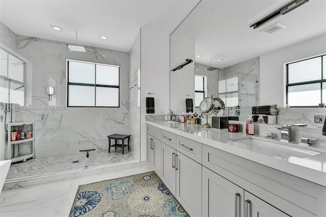 full bath with a wealth of natural light, marble finish floor, a sink, and a marble finish shower