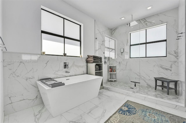 full bath with stone wall, recessed lighting, marble finish floor, a soaking tub, and a marble finish shower