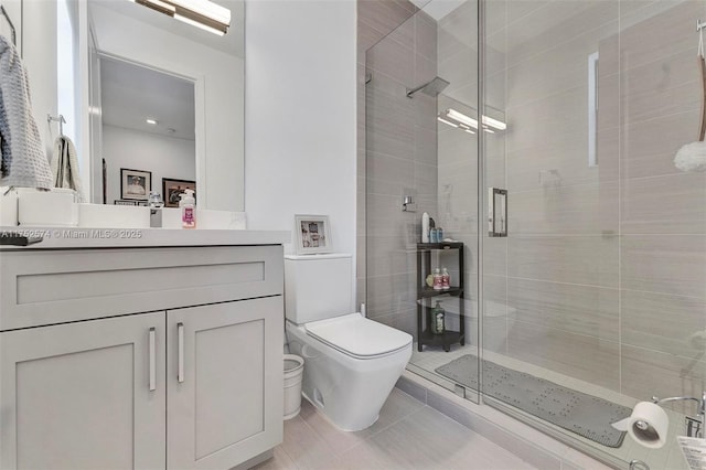 bathroom with toilet, vanity, a shower stall, and tile patterned floors