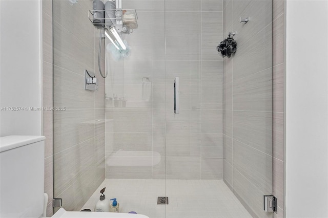 full bathroom featuring a stall shower and toilet