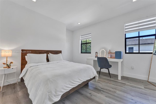 bedroom with light wood-style flooring and baseboards