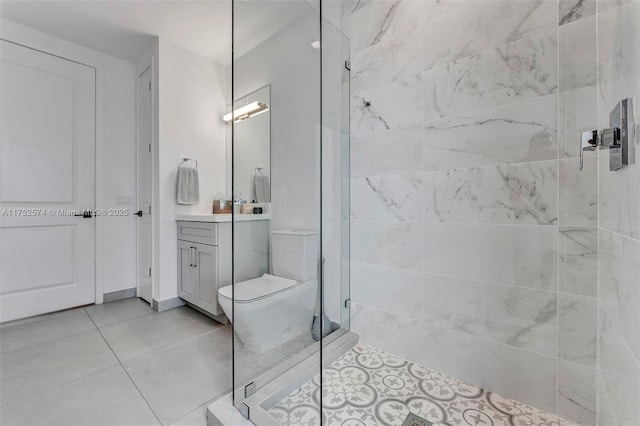 bathroom featuring toilet, vanity, a shower stall, and tile patterned floors