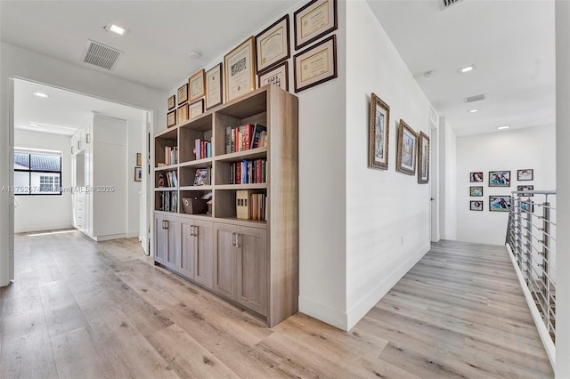 corridor featuring light wood finished floors and visible vents