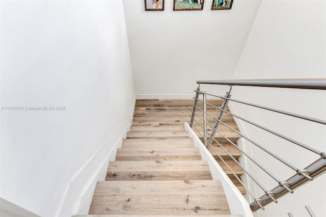 stairway with baseboards and wood finished floors