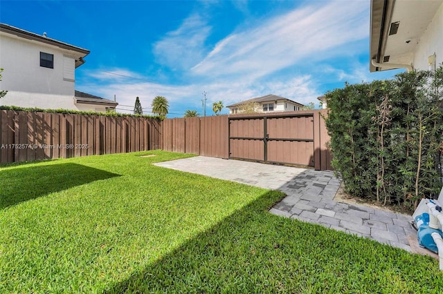 view of yard featuring a patio, a fenced backyard, and a gate