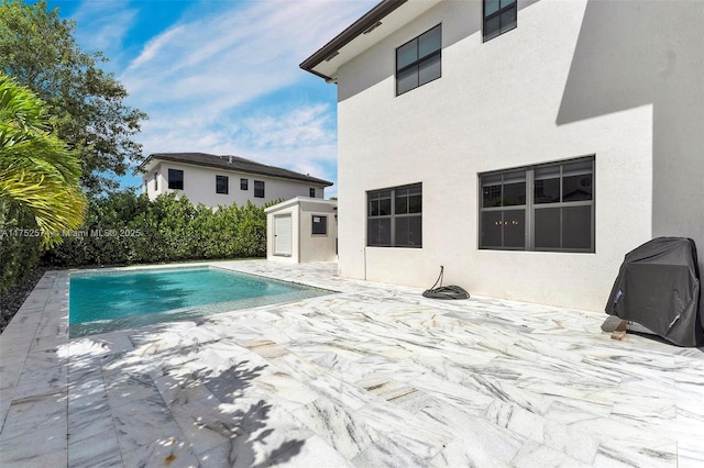 view of pool featuring a patio, a shed, an outdoor structure, and a fenced in pool