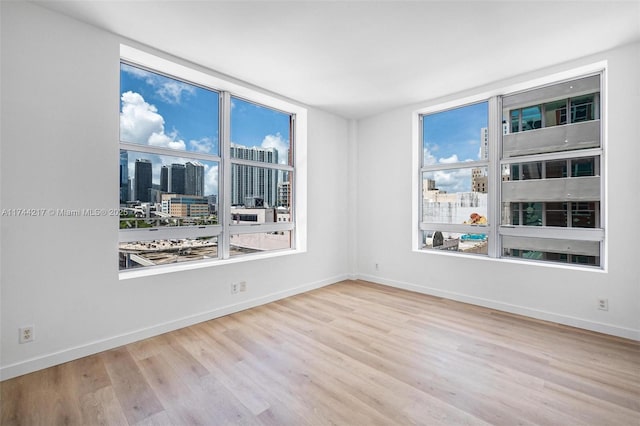 111 E Flagler St Unit 704, Miami, FL 33131 - unfurnished room featuring baseboards, light wood-type flooring, and a city view
