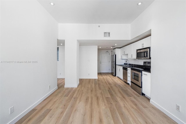 111 E Flagler St Unit 704, Miami, FL 33131 - kitchen featuring visible vents, baseboards, dark countertops, appliances with stainless steel finishes, and white cabinetry