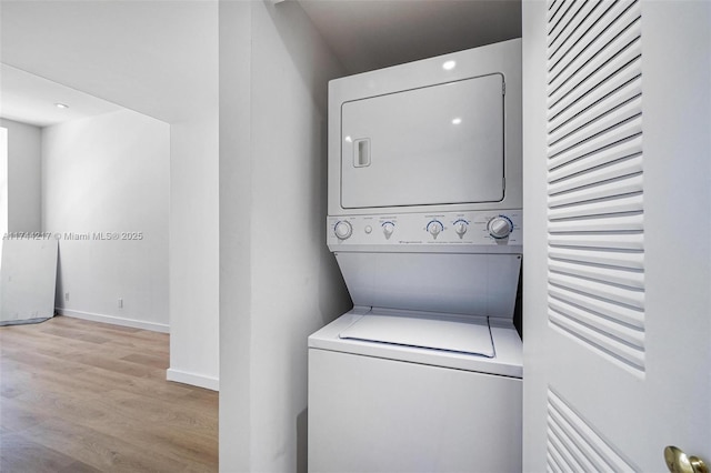 111 E Flagler St Unit 704, Miami, FL 33131 - laundry room with light wood-type flooring, stacked washer / drying machine, laundry area, and baseboards