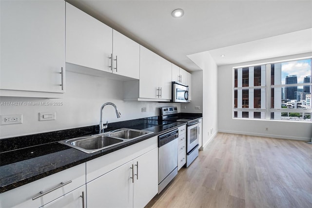 111 E Flagler St Unit 704, Miami, FL 33131 - kitchen with a view of city, a sink, white cabinetry, appliances with stainless steel finishes, and dark stone counters