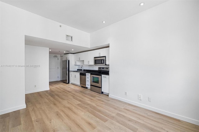 111 E Flagler St Unit 704, Miami, FL 33131 - kitchen with stainless steel appliances, a sink, visible vents, white cabinets, and dark countertops