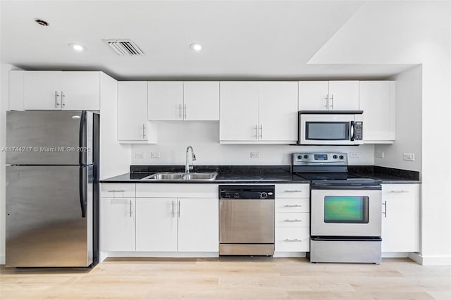 111 E Flagler St Unit 704, Miami, FL 33131 - kitchen with stainless steel appliances, a sink, visible vents, white cabinetry, and light wood finished floors