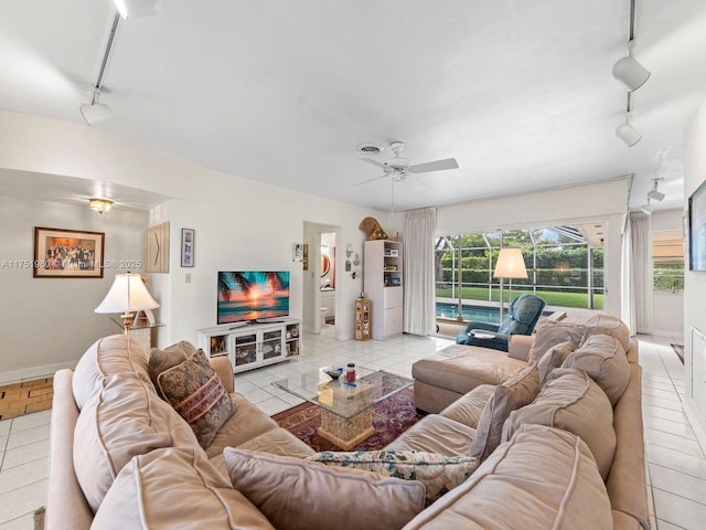 living area with light tile patterned floors, baseboards, a ceiling fan, and track lighting