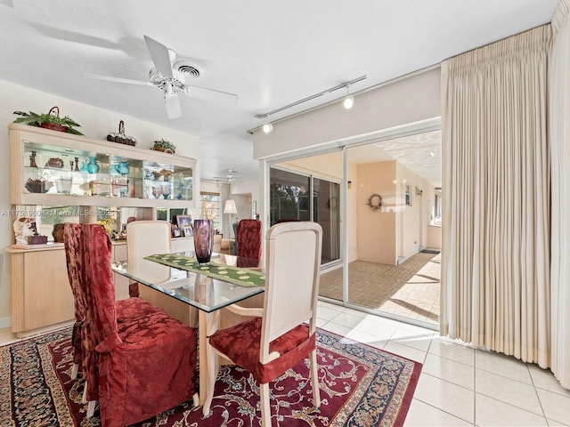 dining space with light tile patterned floors, ceiling fan, and rail lighting