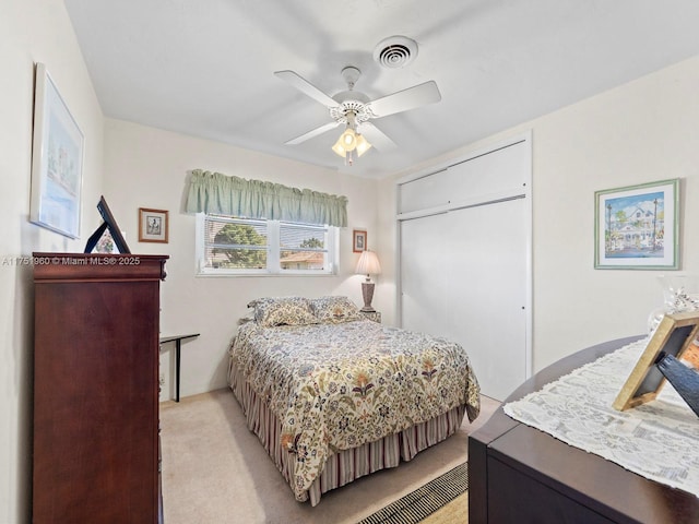 bedroom with a ceiling fan, visible vents, a closet, and light colored carpet