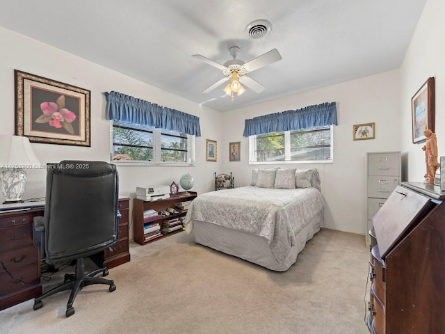 bedroom with light carpet, ceiling fan, and visible vents