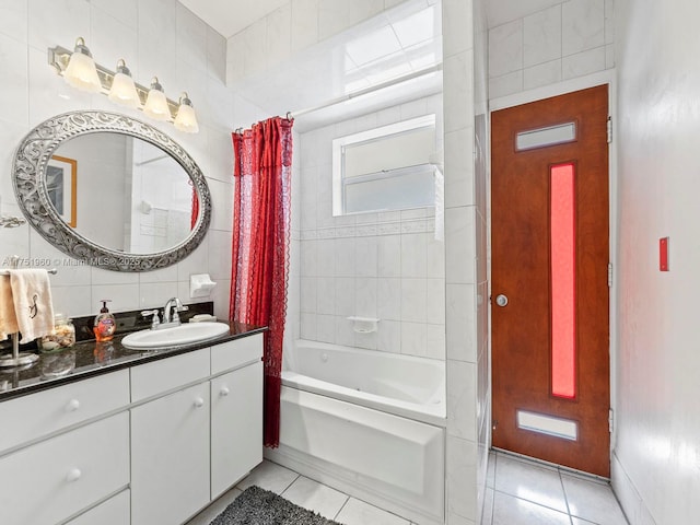 full bath with tile patterned floors, vanity, tile walls, decorative backsplash, and shower / bath combo