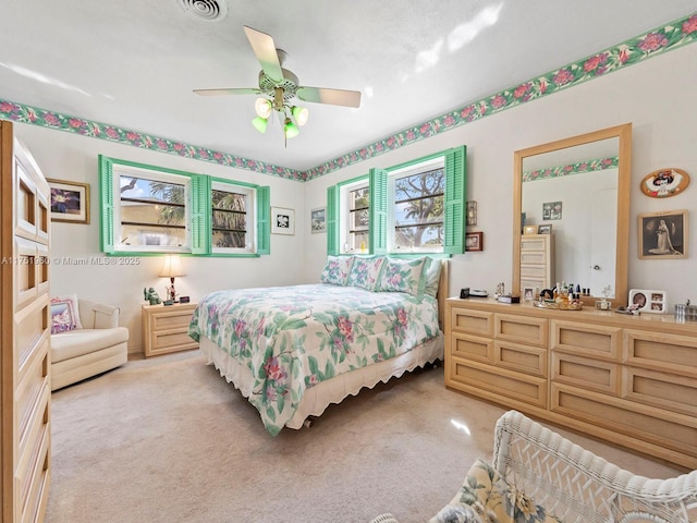 bedroom with ceiling fan and light colored carpet