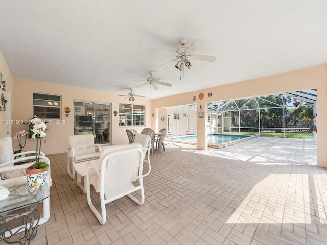 view of patio featuring an outdoor pool, glass enclosure, and ceiling fan