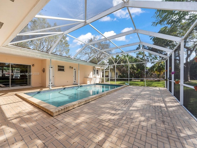 outdoor pool with glass enclosure and a patio area