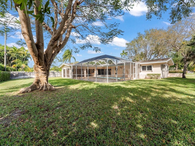 back of property featuring a lanai, stucco siding, a fenced backyard, and a yard