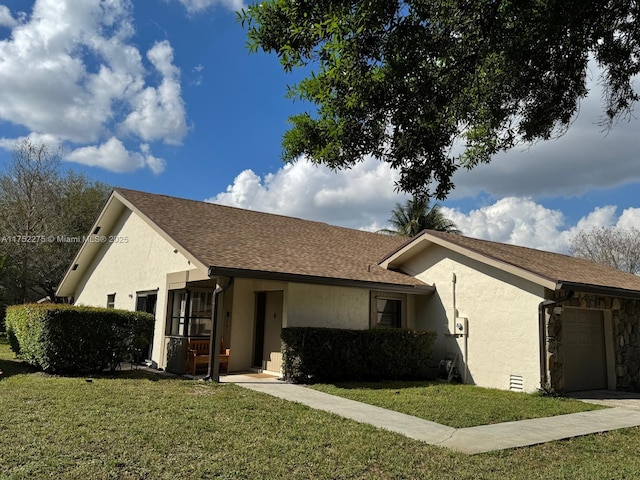 view of side of property with an attached garage, a lawn, and stucco siding