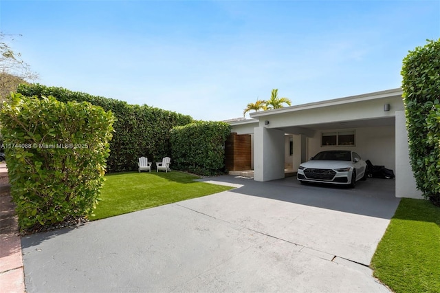 exterior space with driveway, a yard, and stucco siding