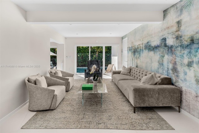 living area with baseboards, beamed ceiling, and light tile patterned flooring