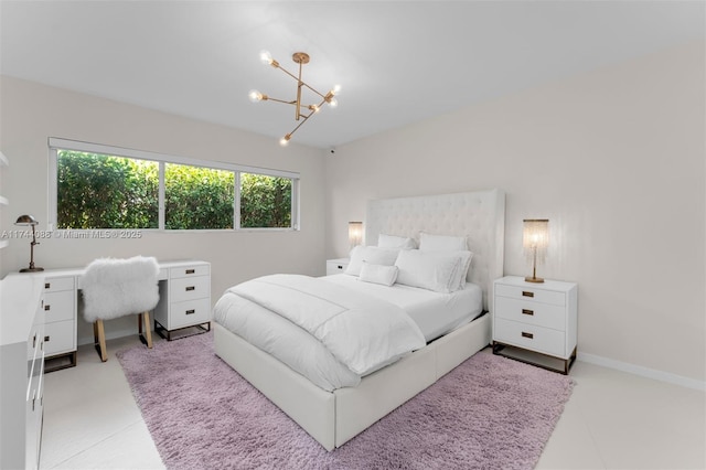 bedroom with a chandelier and baseboards