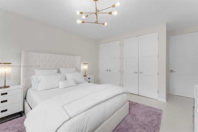 bedroom with multiple closets and a chandelier