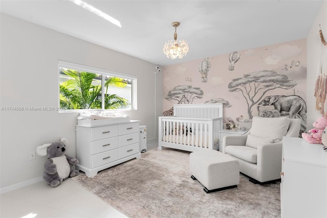 bedroom featuring a nursery area, baseboards, an inviting chandelier, and wallpapered walls