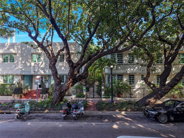 multi unit property with a fenced front yard and stucco siding