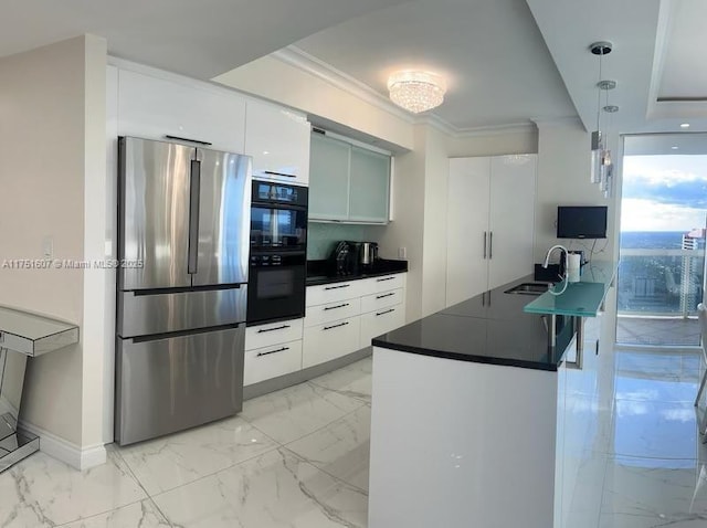 kitchen featuring white cabinets, dark countertops, modern cabinets, freestanding refrigerator, and hanging light fixtures