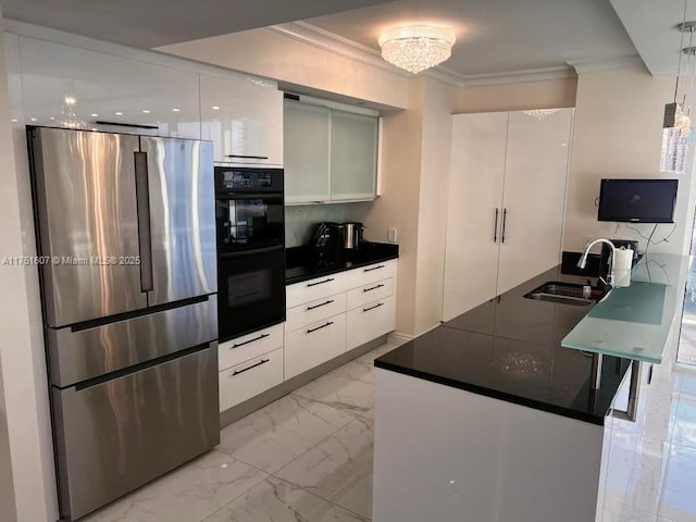 kitchen with dark countertops, dobule oven black, freestanding refrigerator, white cabinetry, and a sink