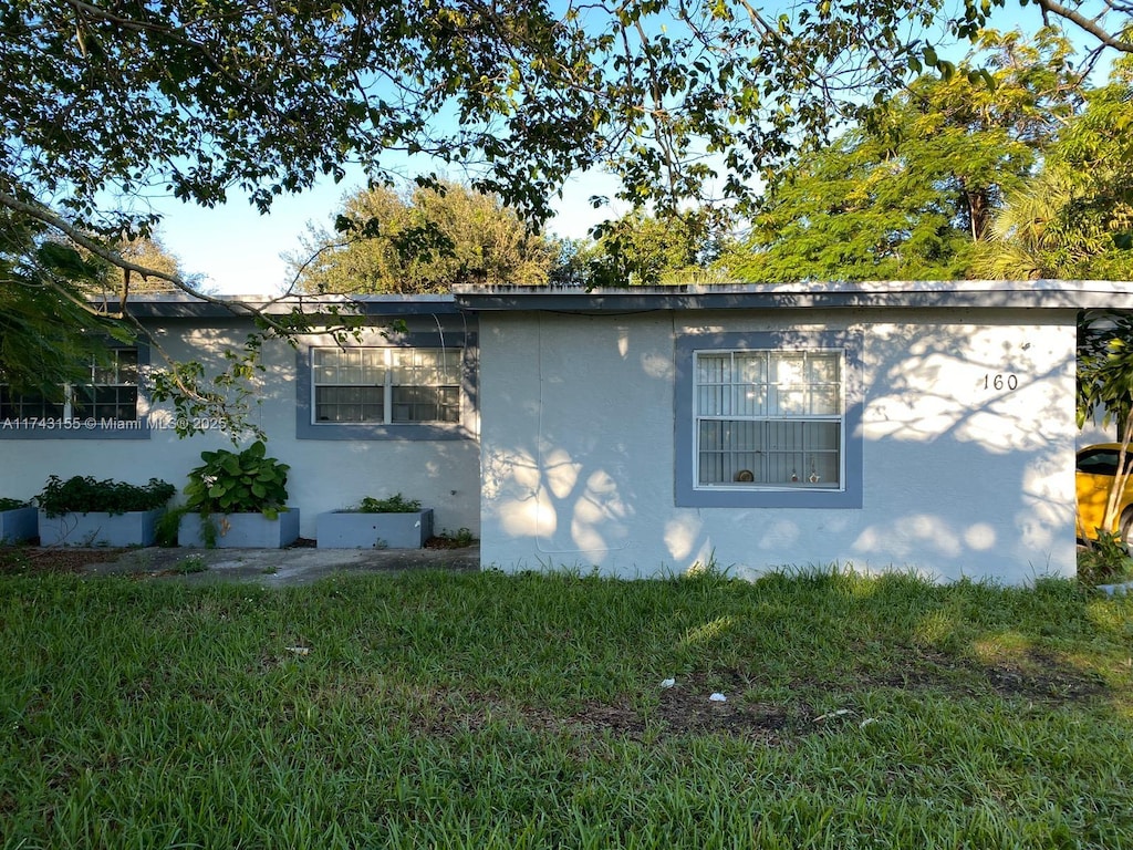 view of side of property with a yard and stucco siding