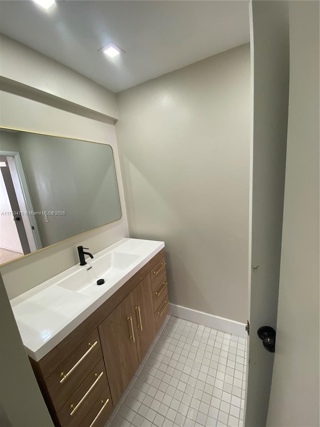 bathroom featuring vanity, baseboards, and tile patterned floors