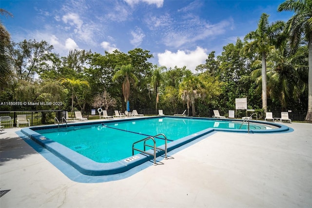 pool with fence and a patio