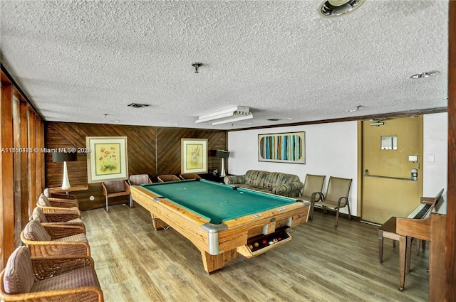 recreation room featuring pool table, visible vents, wood walls, a textured ceiling, and wood finished floors