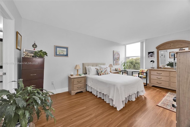 bedroom featuring light wood-style flooring and baseboards