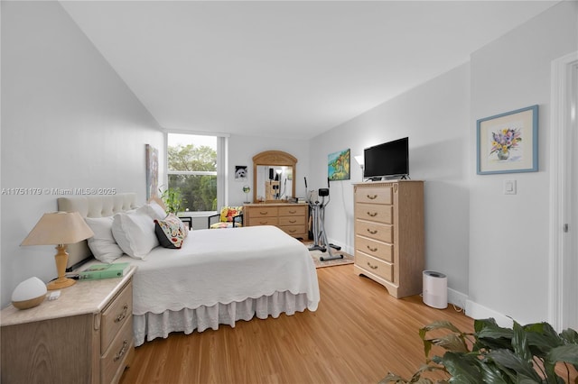 bedroom featuring baseboards and light wood finished floors