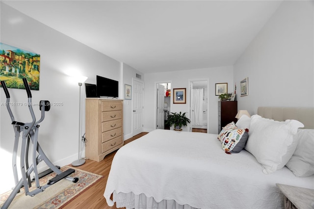 bedroom featuring light wood finished floors, baseboards, and visible vents