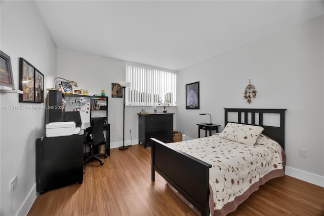 bedroom with baseboards and wood finished floors