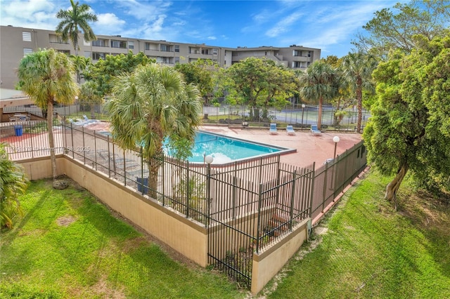 community pool featuring a lawn and fence