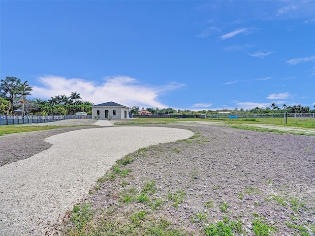 exterior space featuring gravel driveway and fence