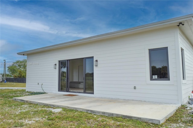 rear view of house with a patio area and a lawn