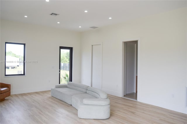 living room with light wood-type flooring, recessed lighting, visible vents, and baseboards